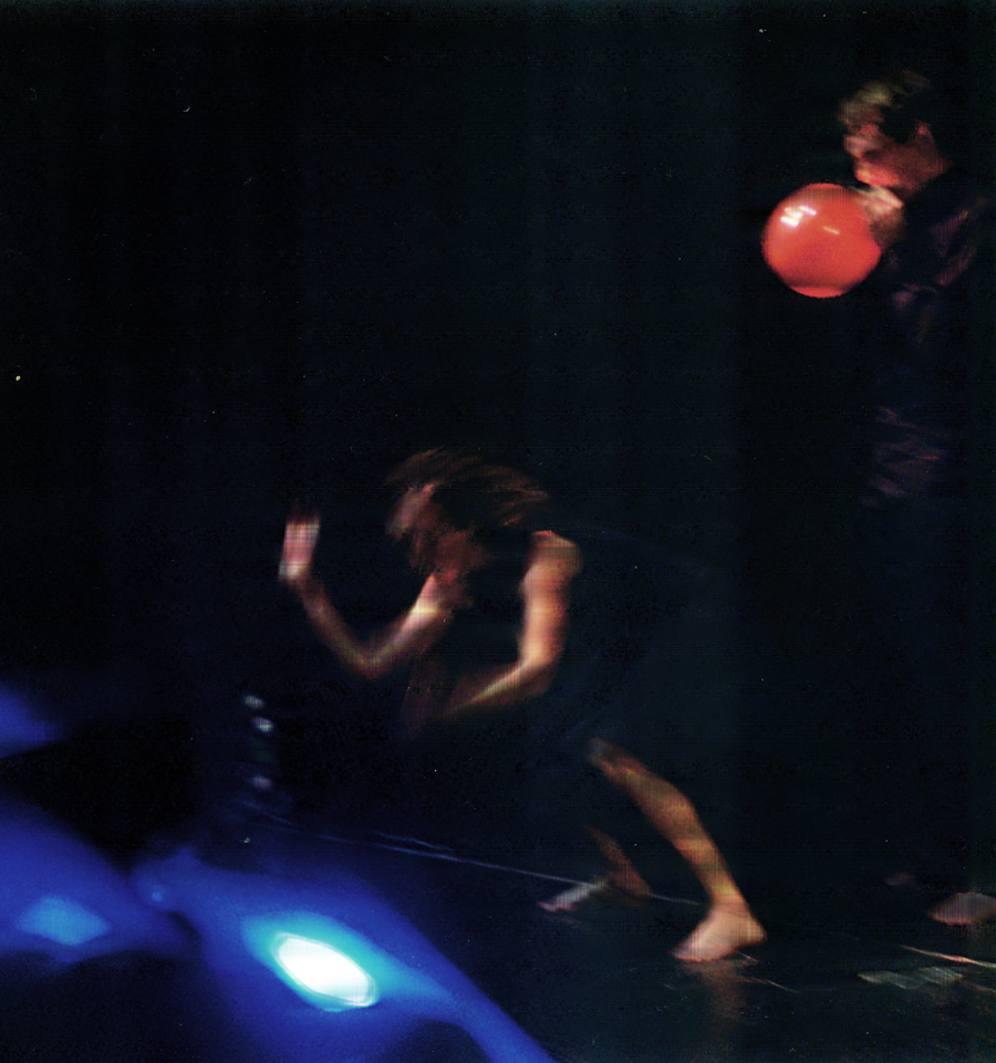 Mextoys: blurred figures in motion, a red balloon, and blue stage light against a dark background
